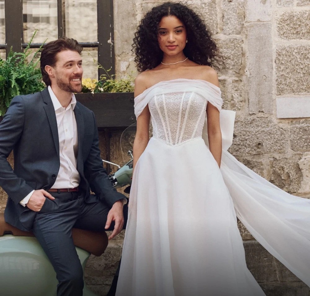 Model wearing a white gown by Rebecca Ingram